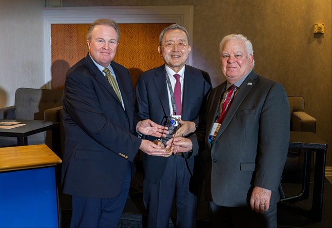 ASPA Executive Director William Shields (left) and President John Bartle (right) present a plaque of appreciation to Professor Pan Suk Kim (center)